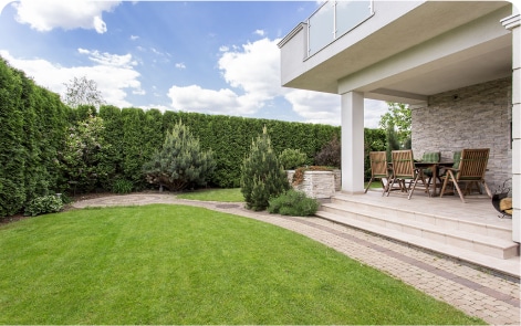 A manicured lawn and neatly trimmed hedges reflecting expert garden maintenance